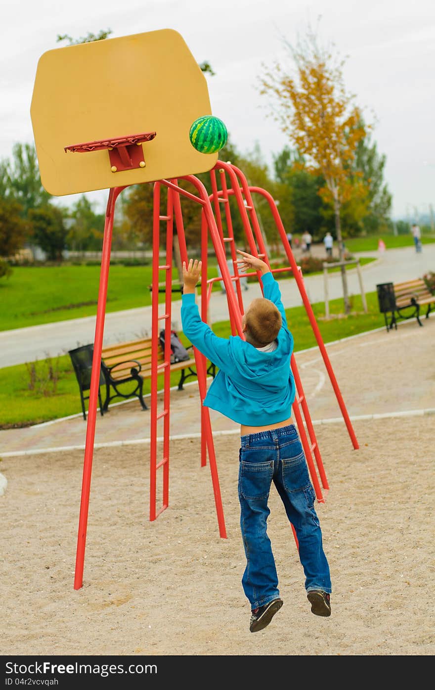 Young boy playing basketball at outdoors playground