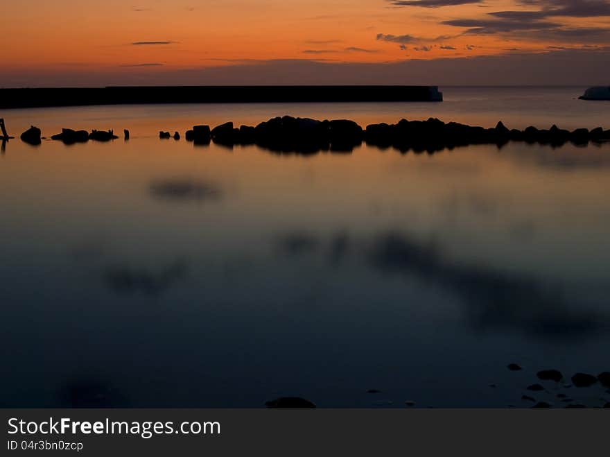 Beautiful sunrise In Kivik, colorful sky and calm water