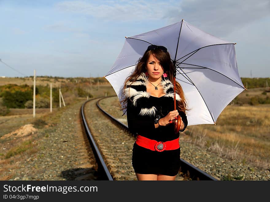 Pretty young woman standing by a railroad. Pretty young woman standing by a railroad