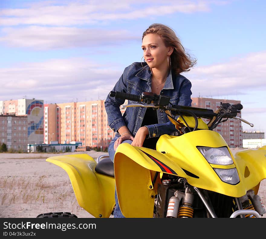 Beautiful blonde on sport quadrocycle on background of the city Nadym. Beautiful blonde on sport quadrocycle on background of the city Nadym.