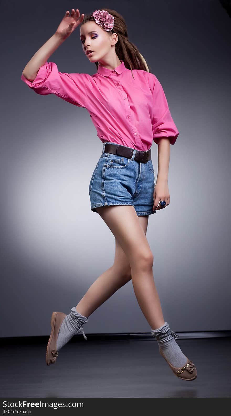 Motion - active girl in elegant jeans shorts, studio shot. Motion - active girl in elegant jeans shorts, studio shot