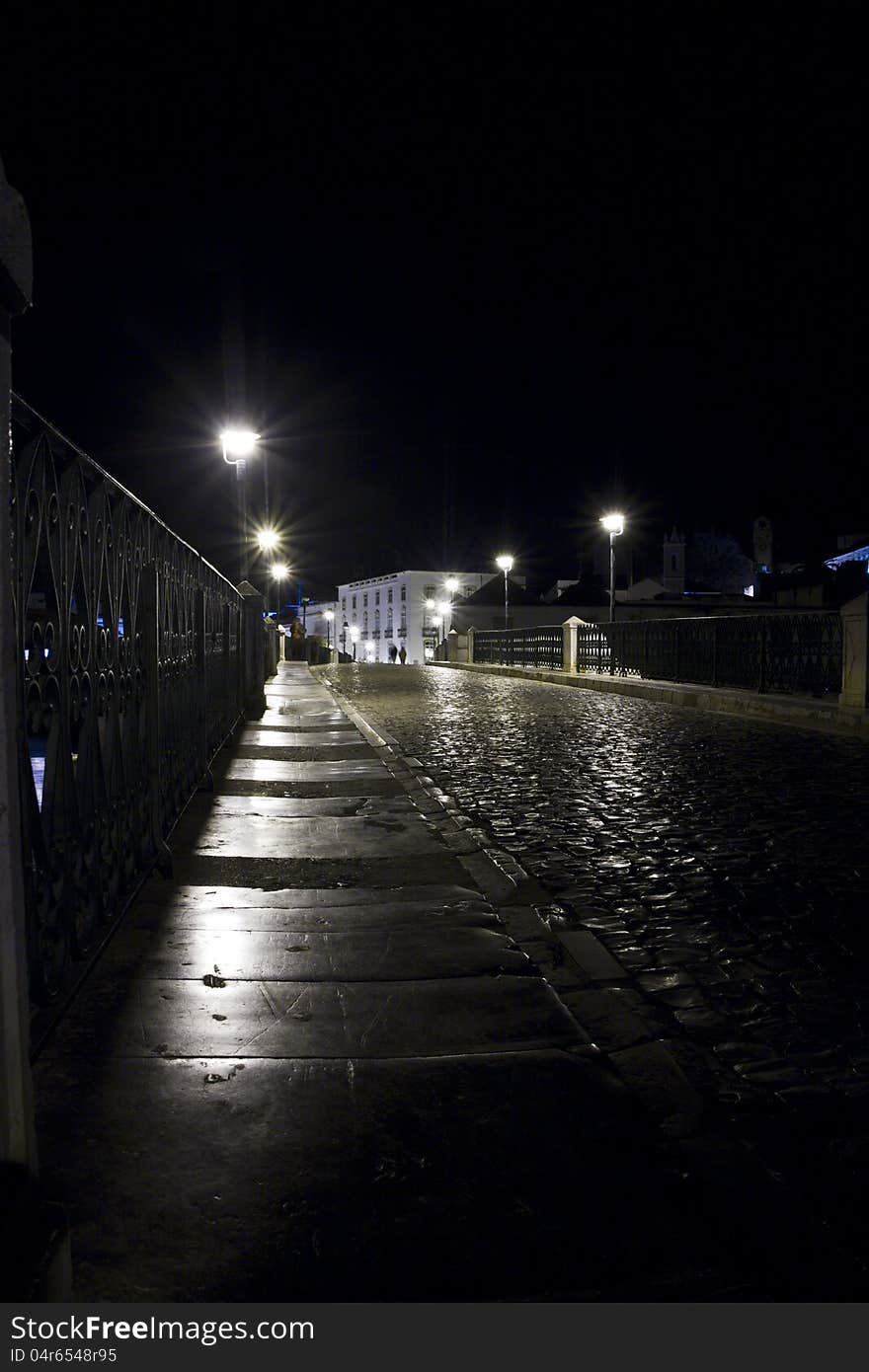 View of a eerie Tavira street in the night located in the Algarve, Portugal. View of a eerie Tavira street in the night located in the Algarve, Portugal.