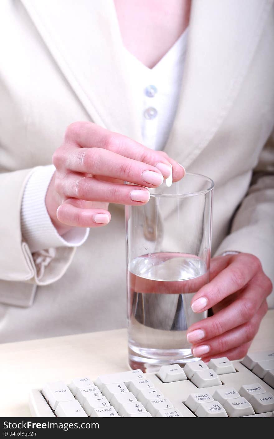 Image of a young woman taking a painkiller after a long day. Image of a young woman taking a painkiller after a long day