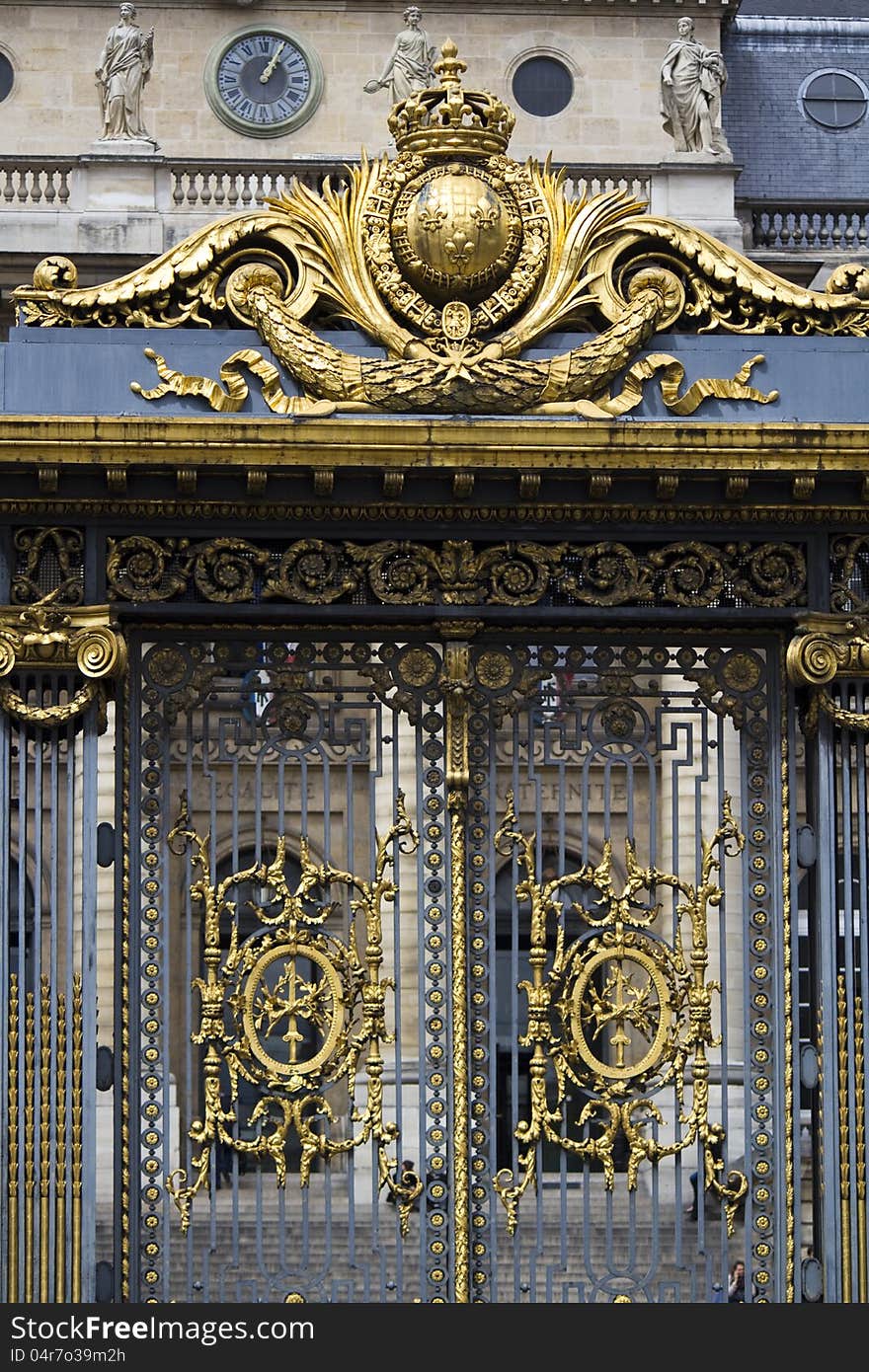 Partial view of a beautiful golden gate on a building in Paris, France.