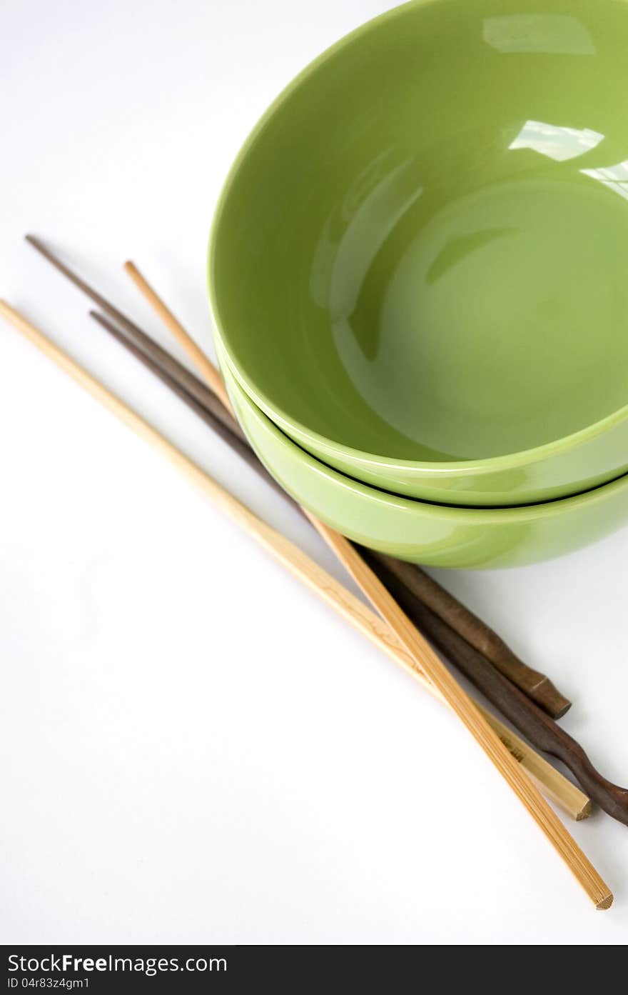 Green bowl and chopstick on white background