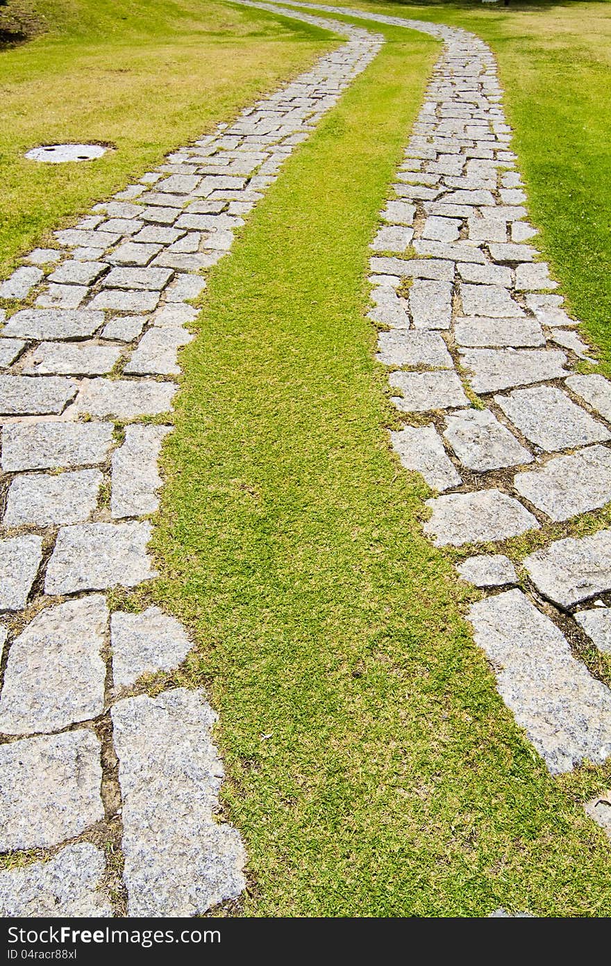 View of a curved cobblestone road on a urban park.