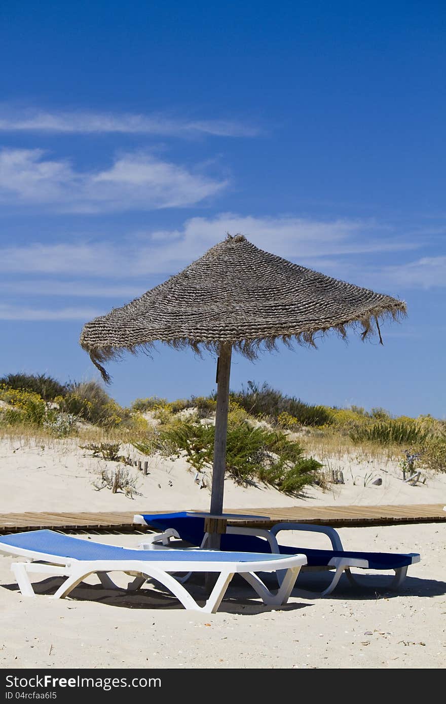 Beach chair with straw umbrella