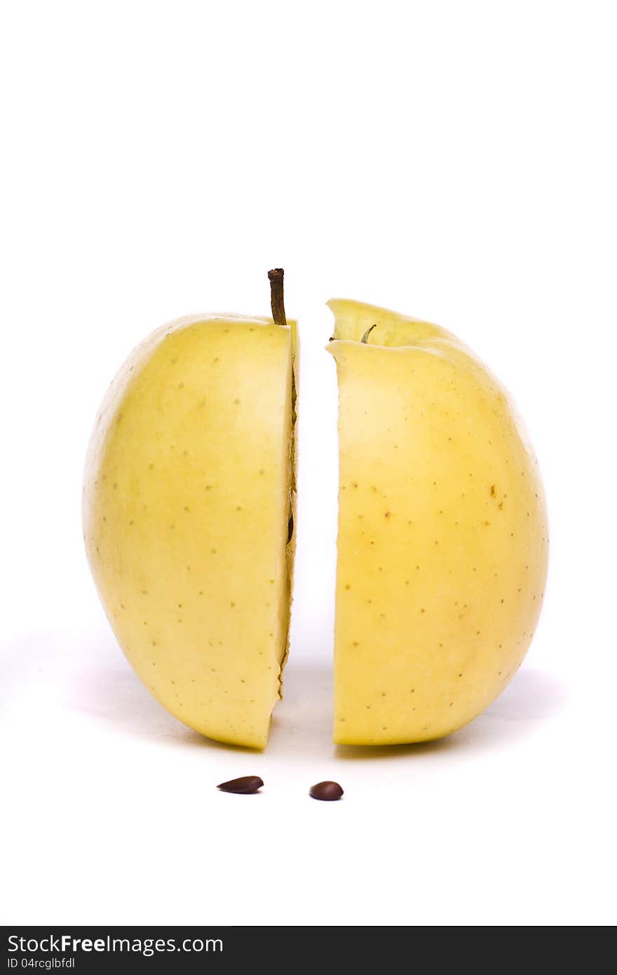 Yellow apple sliced in half on white