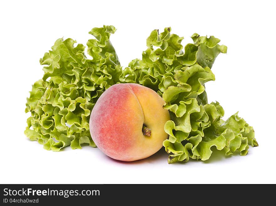 Peach with lettuce on white