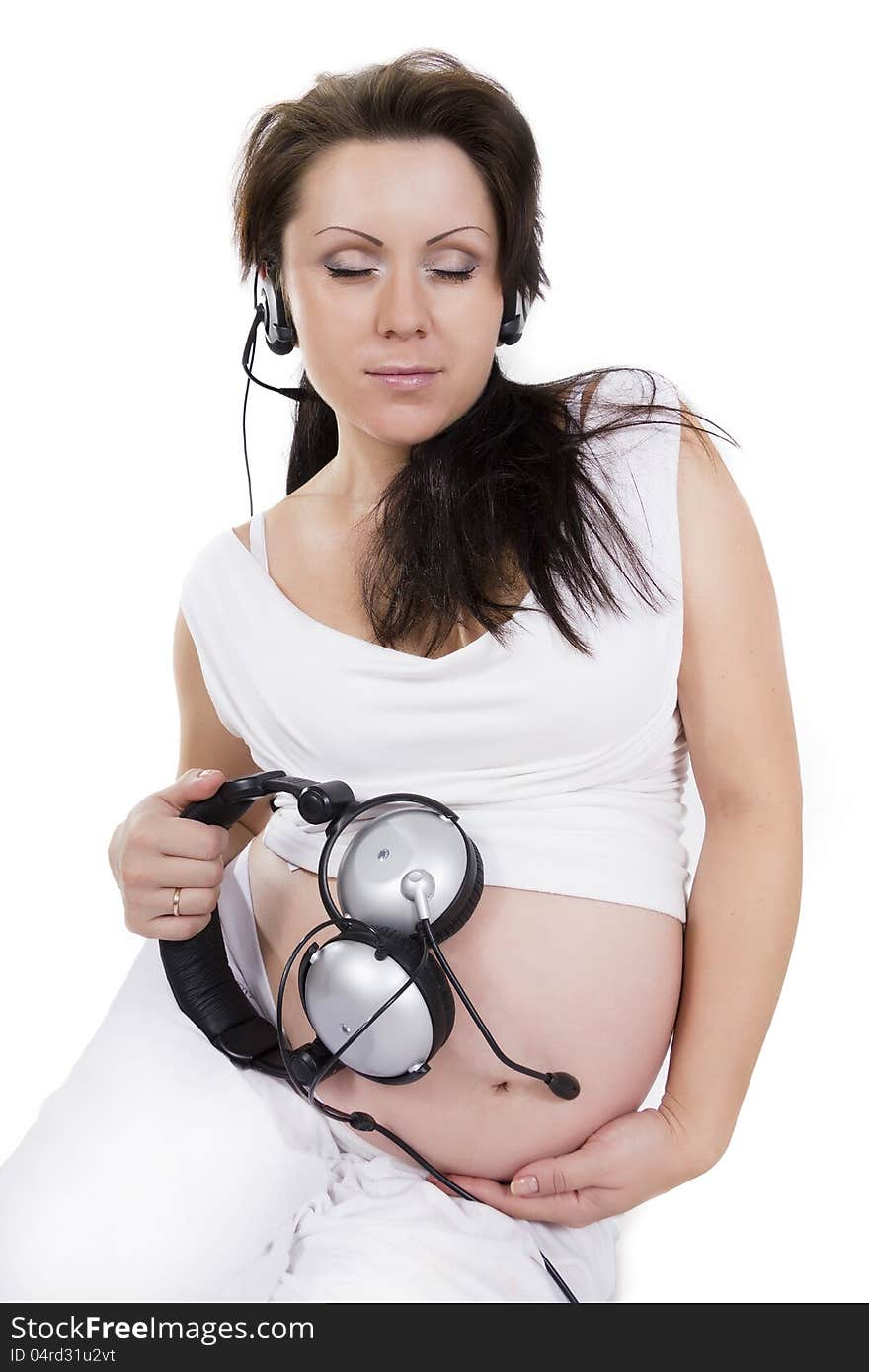 Music for two. The pregnant woman in earphones listens to music. Music for two. The pregnant woman in earphones listens to music