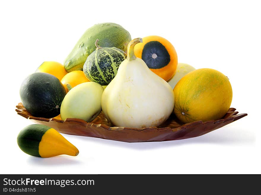 Wooden tray with small assorted gourds isolated on a white background