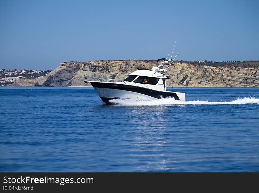 View of a fast vacation yatch speeding on the water.