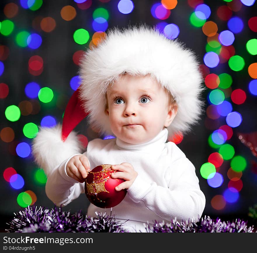 Baby boy in Santa Claus hat on bright festive background. Baby boy in Santa Claus hat on bright festive background