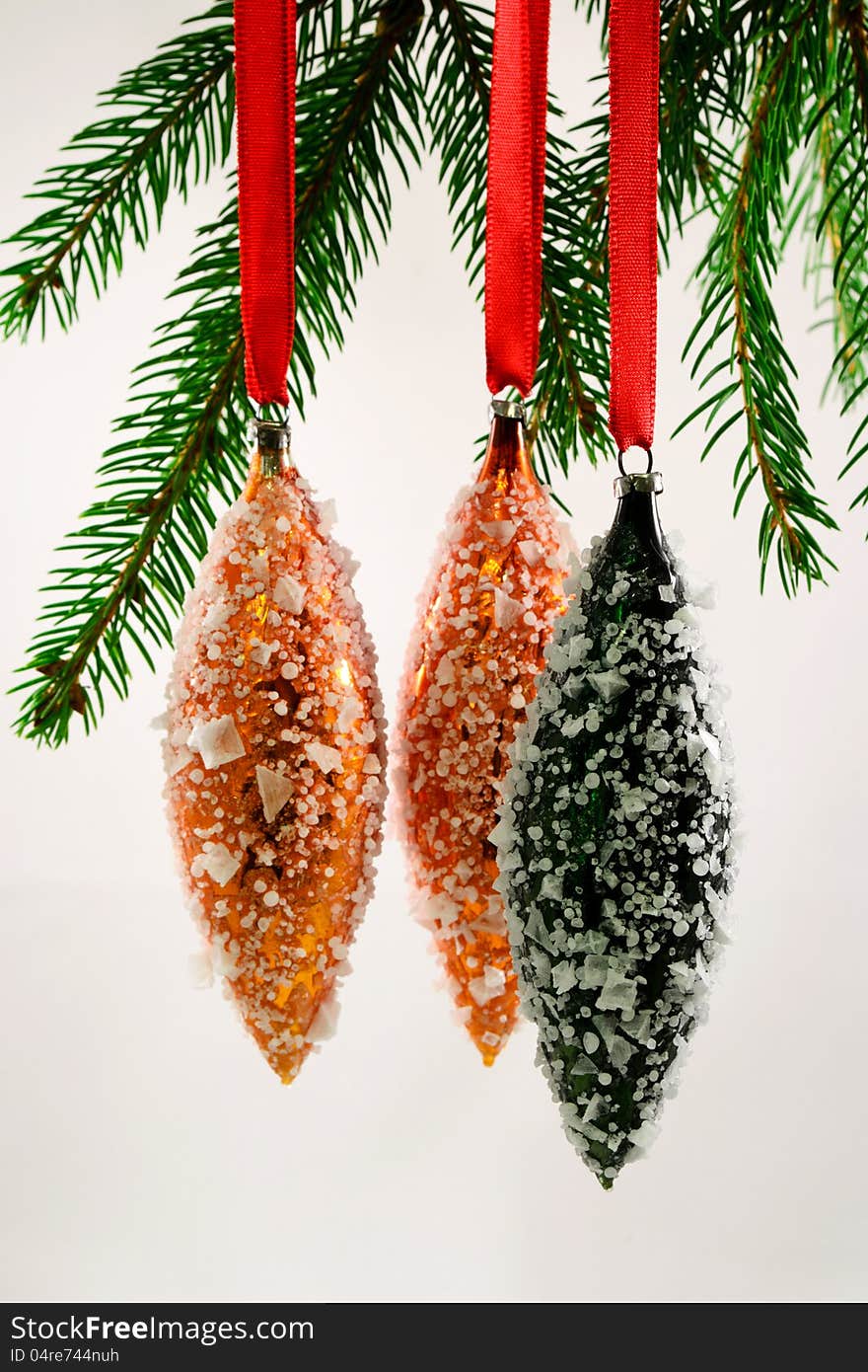 Three oval shaped  Christmas tree ornaments with false frost hanging. Three oval shaped  Christmas tree ornaments with false frost hanging