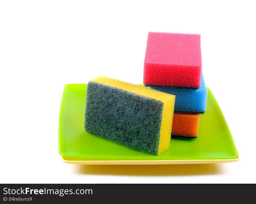 Colorful Dish sponge on a plastic plates, white background. Colorful Dish sponge on a plastic plates, white background