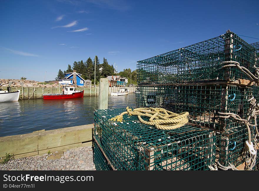 Wide angle view of lobster traps and colorful fishing boats at high tide Harbourville,Nova Scotia.This small fishing village is on the Bay of Fundy where the tides are highest in the world. Wide angle view of lobster traps and colorful fishing boats at high tide Harbourville,Nova Scotia.This small fishing village is on the Bay of Fundy where the tides are highest in the world.