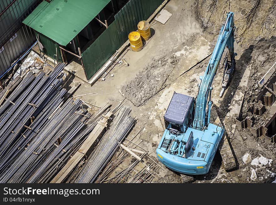 Construction in bird eye view with green backhoe .