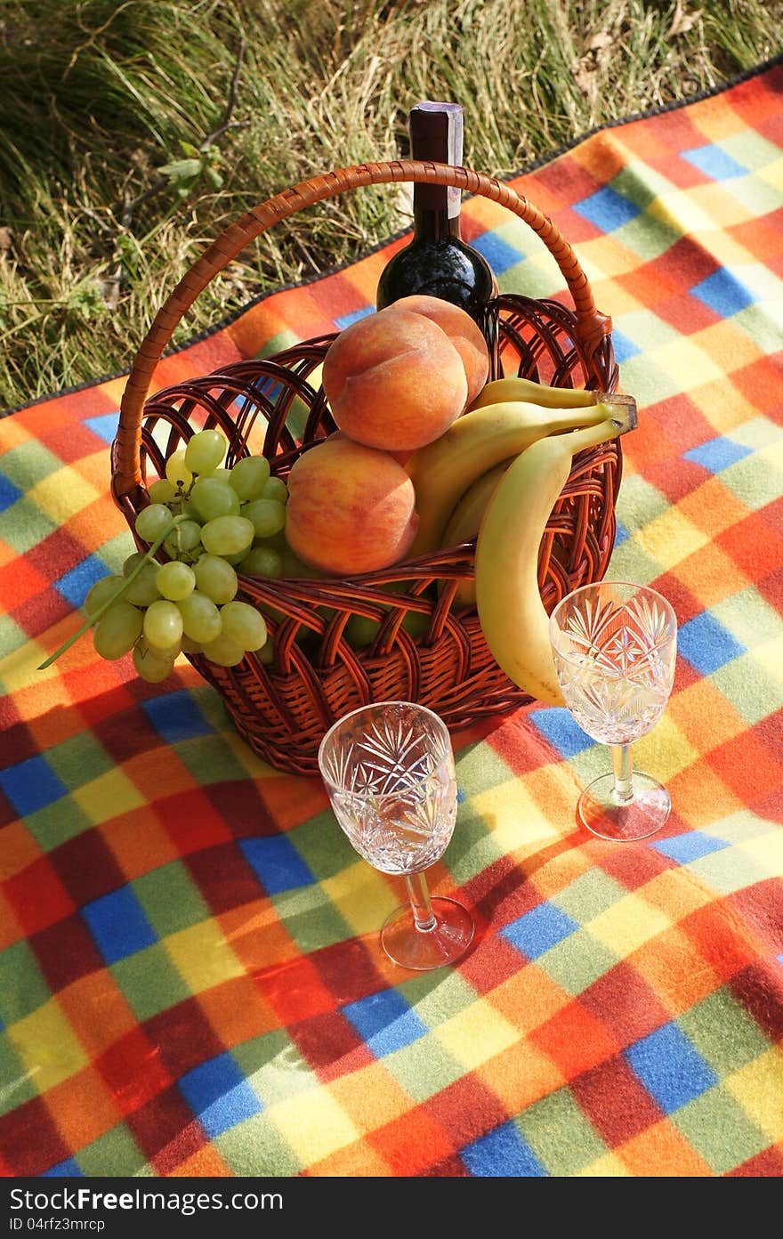 Wicker fruit basket and a bottle of wine. Wicker fruit basket and a bottle of wine