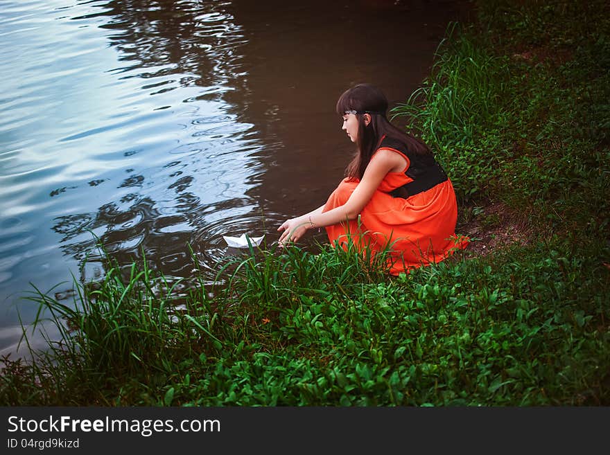 Girl Sitting By A Lake