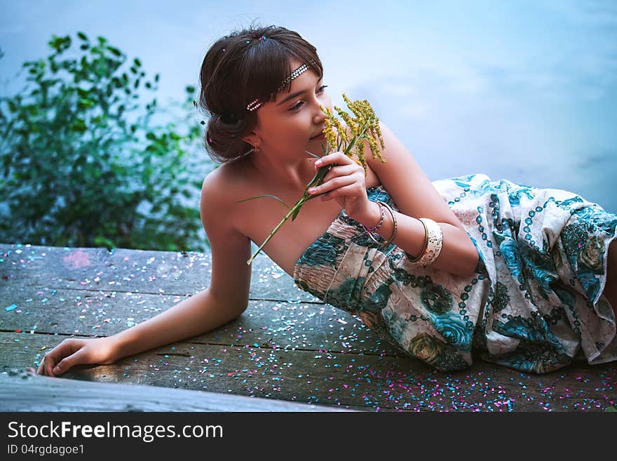 Girl Sitting By A Lake