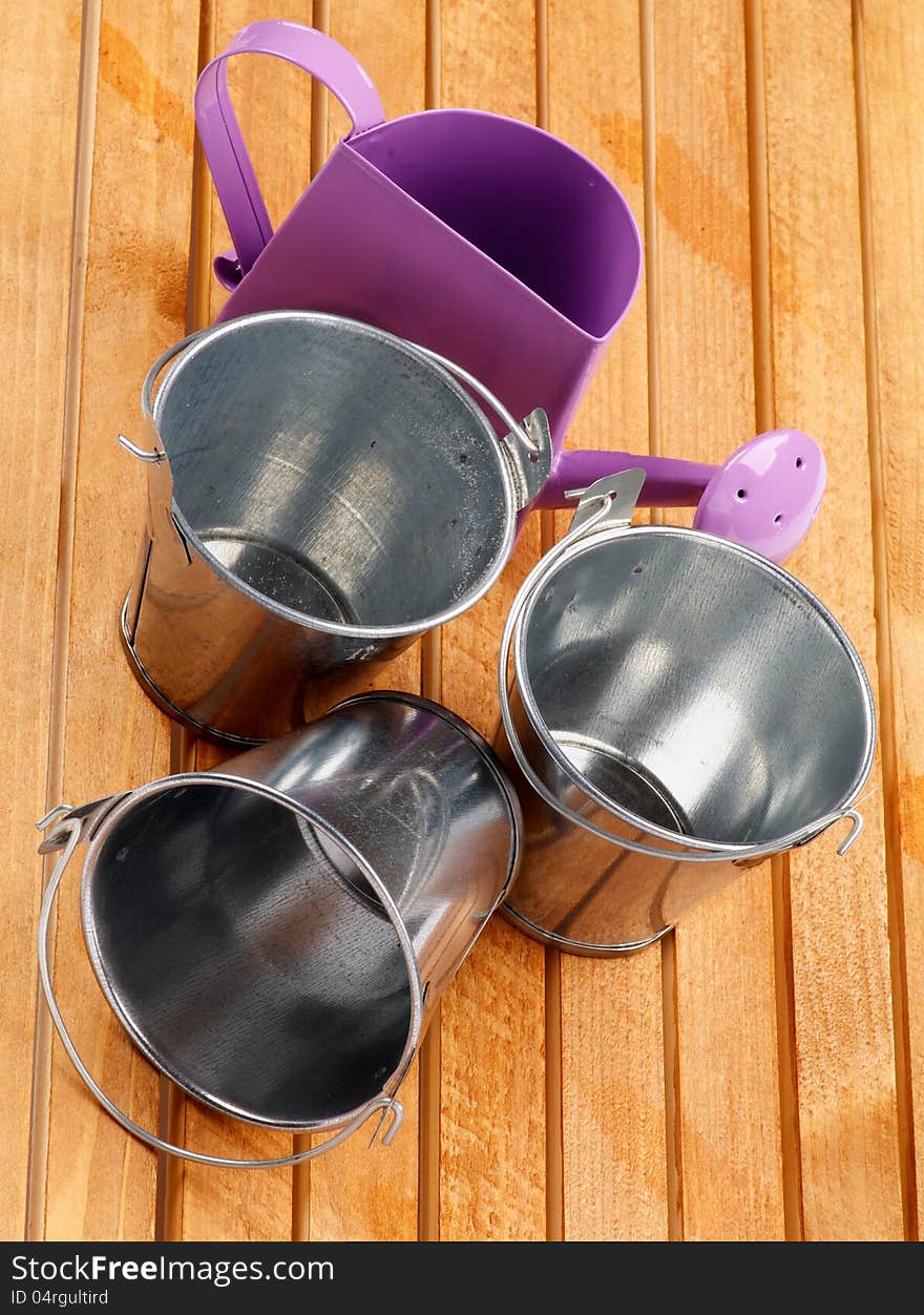 Garden Utensil with Tin Buckets and Watering Can on wooden background