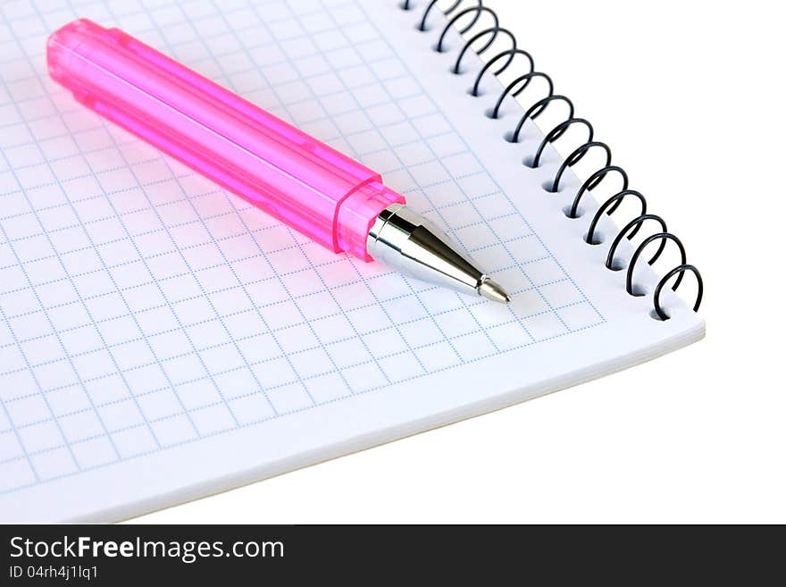 Pink pen lies on a notebook on a white background