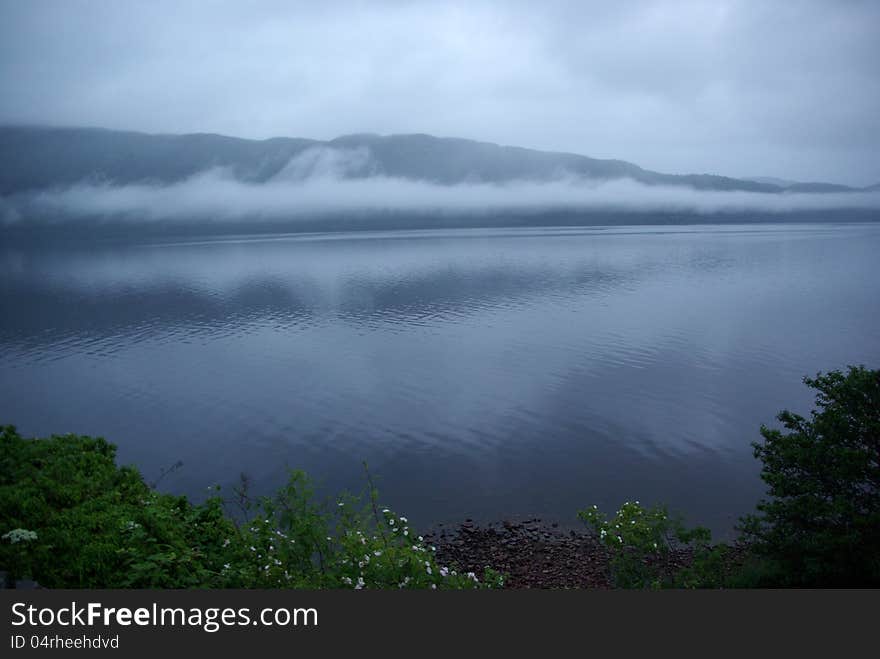 Scotland's Loch Ness with fog and rainy sky. Scotland's Loch Ness with fog and rainy sky.