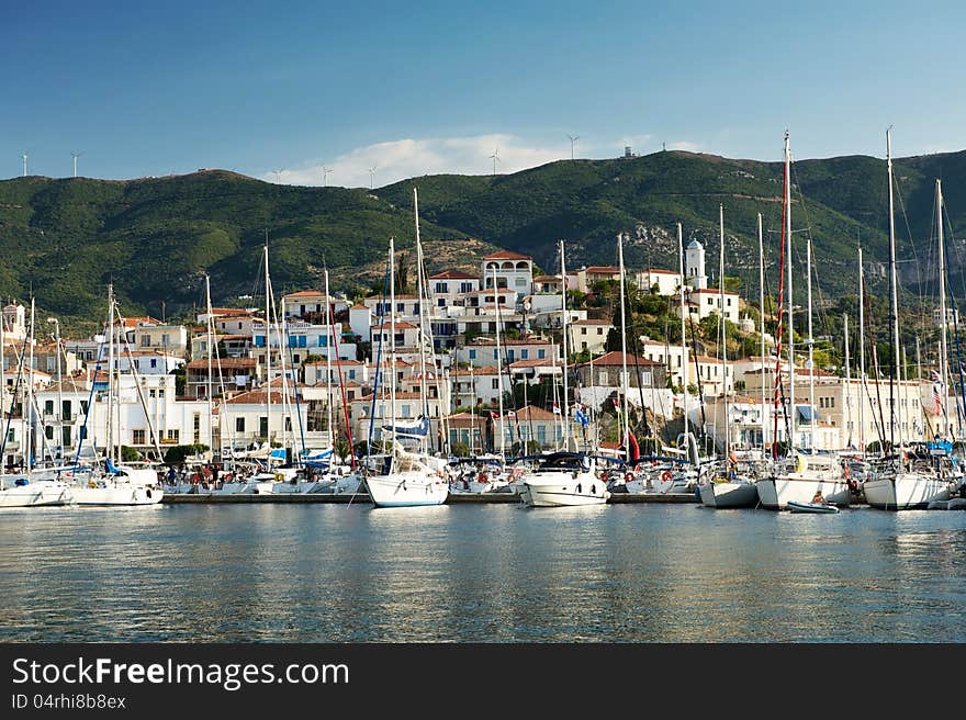 View of the Poros island, boats, village and hills behind from the sea, Greece. View of the Poros island, boats, village and hills behind from the sea, Greece