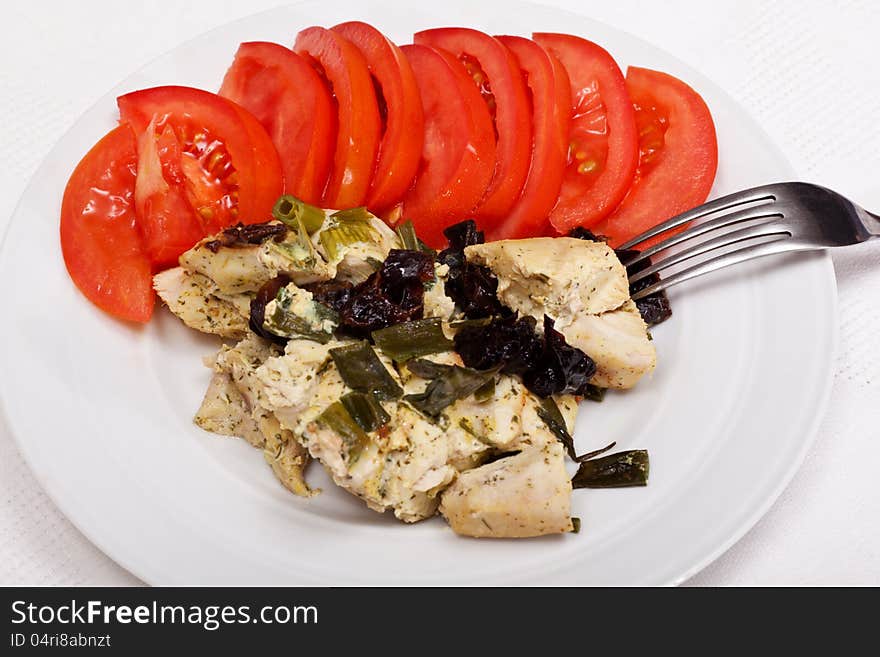 Dinner from chicken breast, prunes and tomatoes