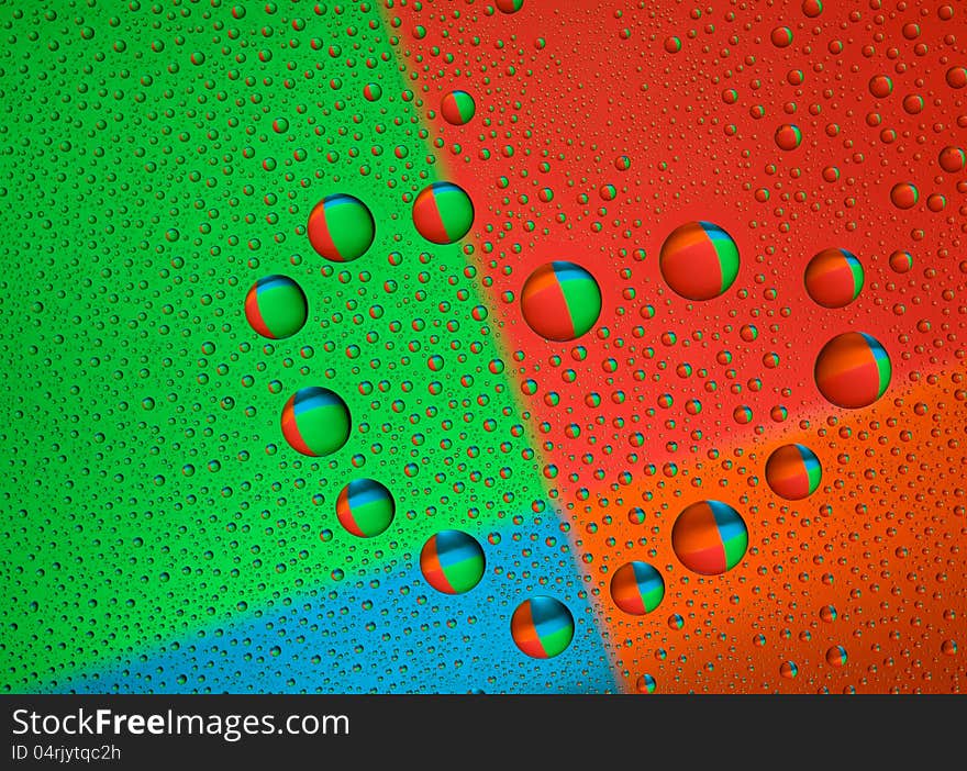 Drops of water on glass in a heart shaped. Colorful background is reflected in the drops. macro. Drops of water on glass in a heart shaped. Colorful background is reflected in the drops. macro