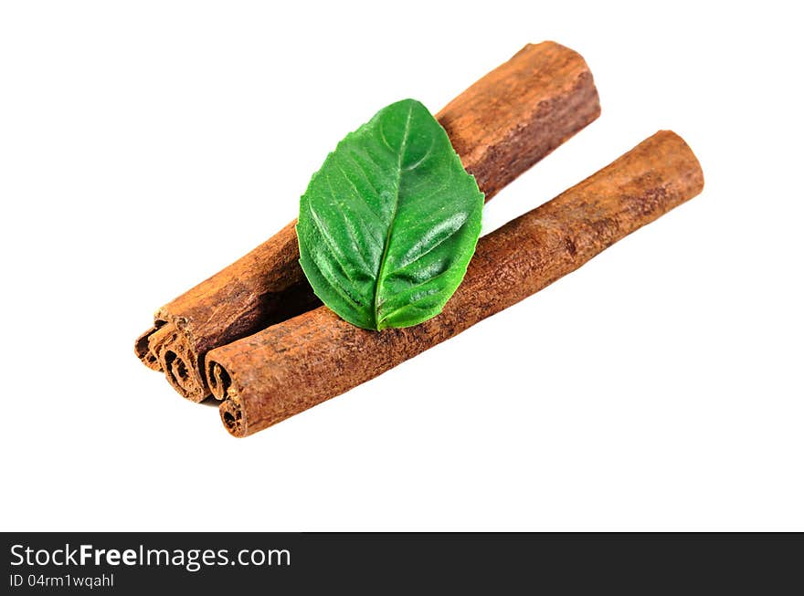 Cinnamon sticks and basil leaf isolated on a perfect white background