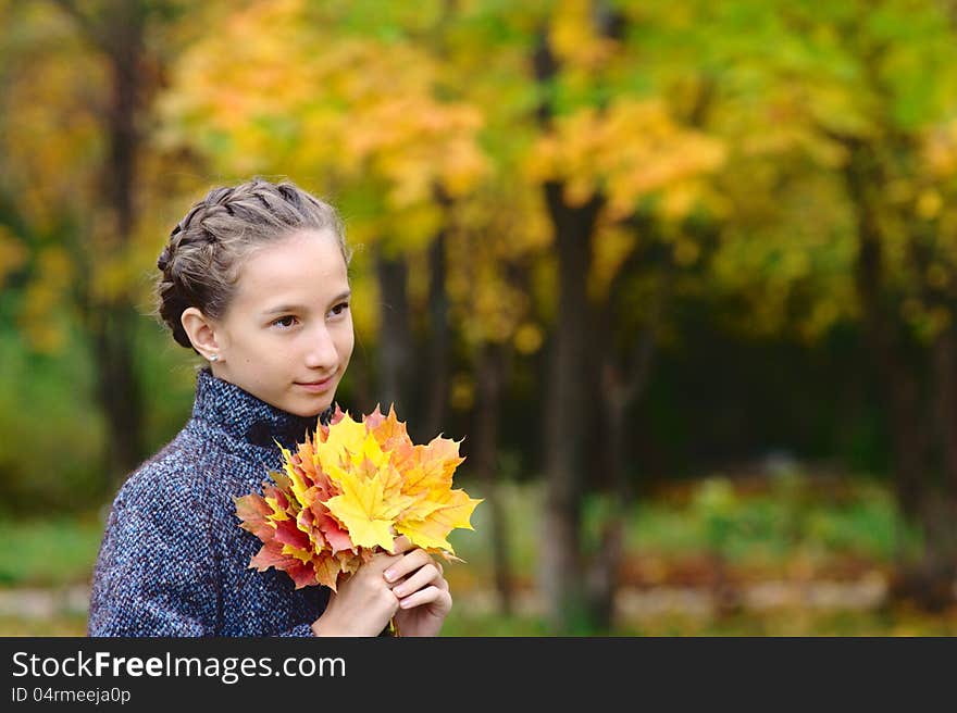 Portrait of Girl with maple leaves in the park