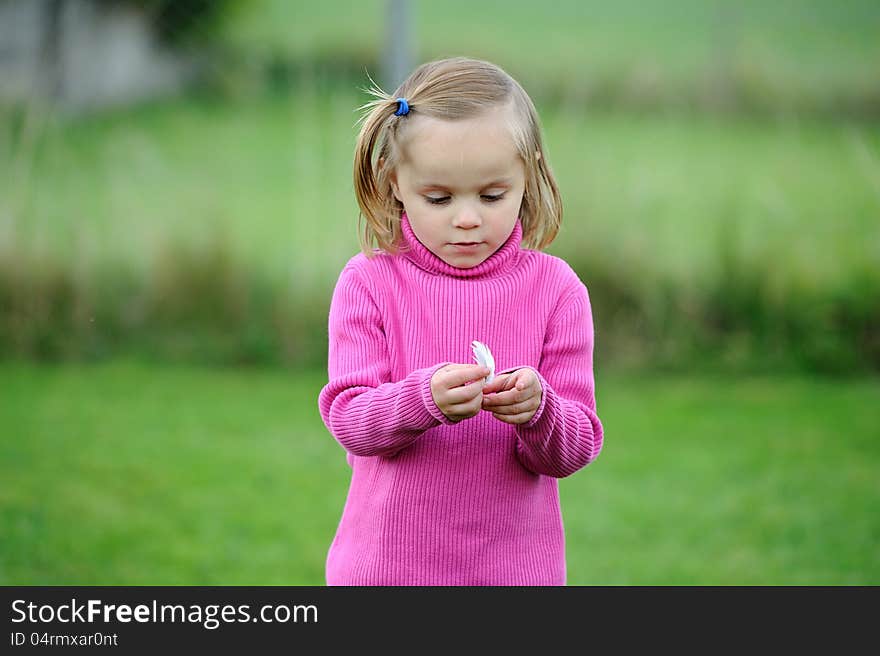 A young girl holding a feather. A young girl holding a feather.