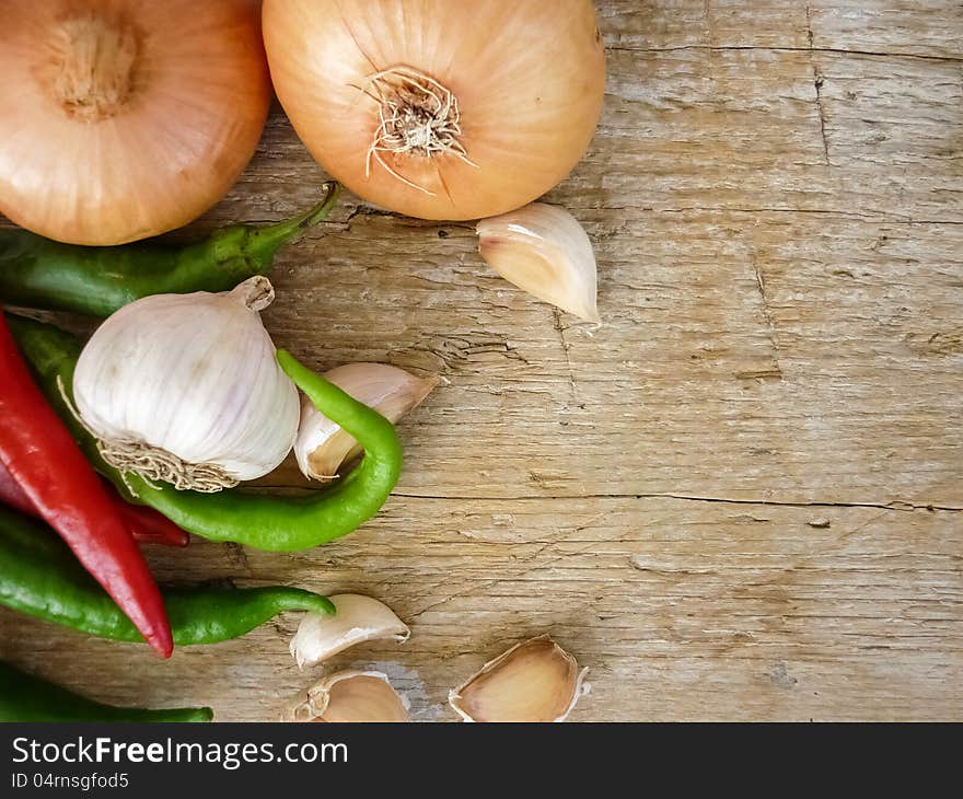 Still life garlic pepper onion on a wooden surface. Still life garlic pepper onion on a wooden surface