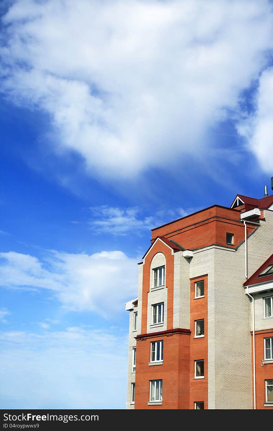 Photo of white-red brick house with red roof against beautiful sky. Photo of white-red brick house with red roof against beautiful sky