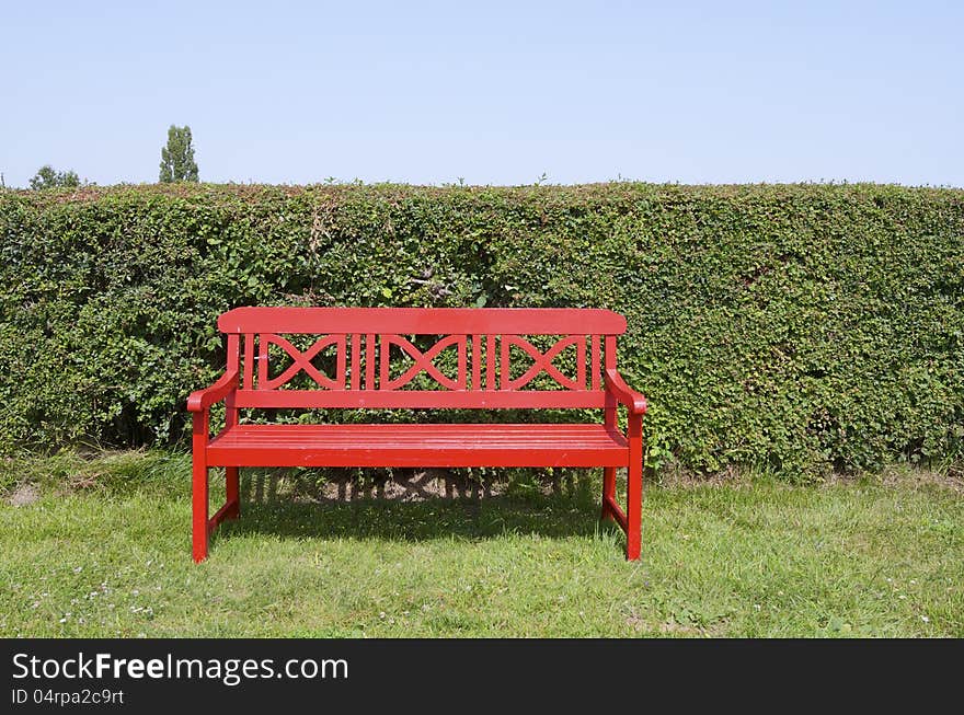 Closeup of a red empty bench in a park