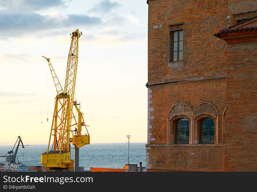 Large yellow cargo crane in sea port of Ancona Italy