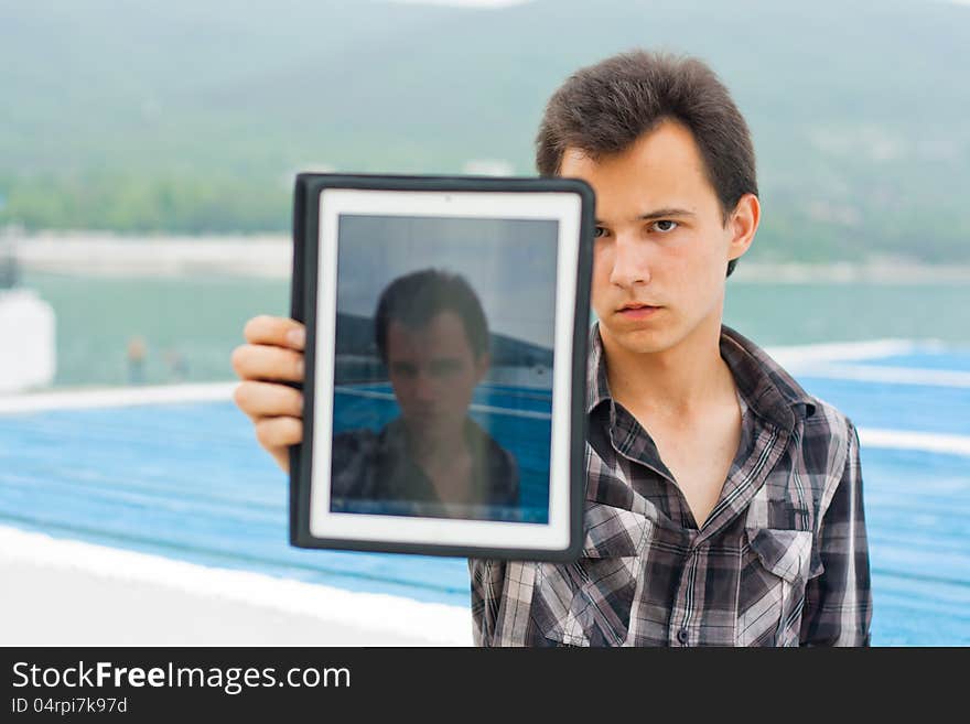 Young man showing photo on the flatbed computer. Young man showing photo on the flatbed computer