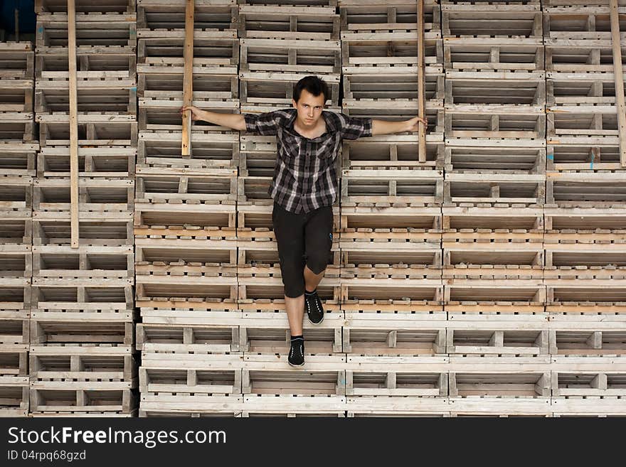 Young man stay near the boards look like cross