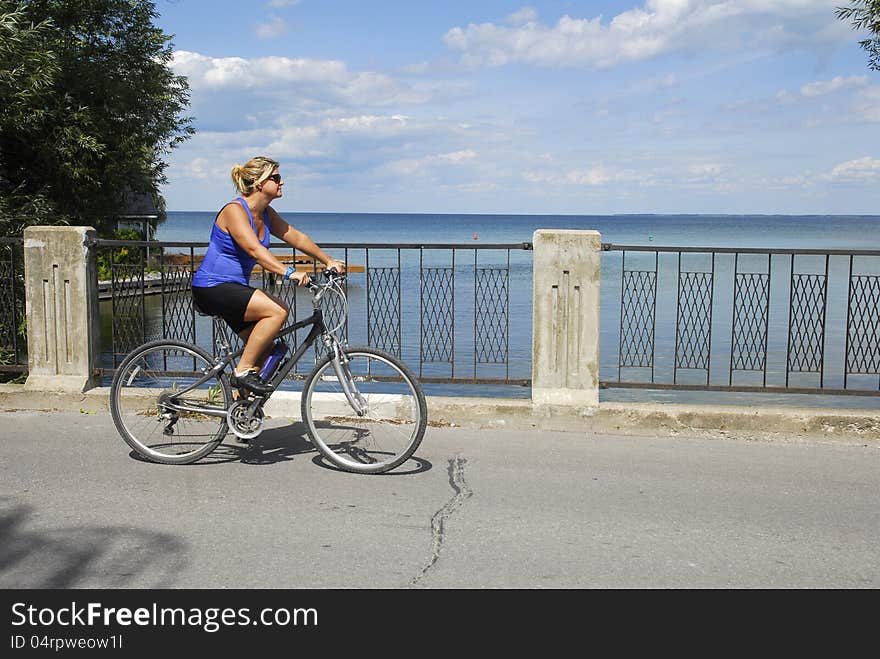 Woman cyclist passing a lake view