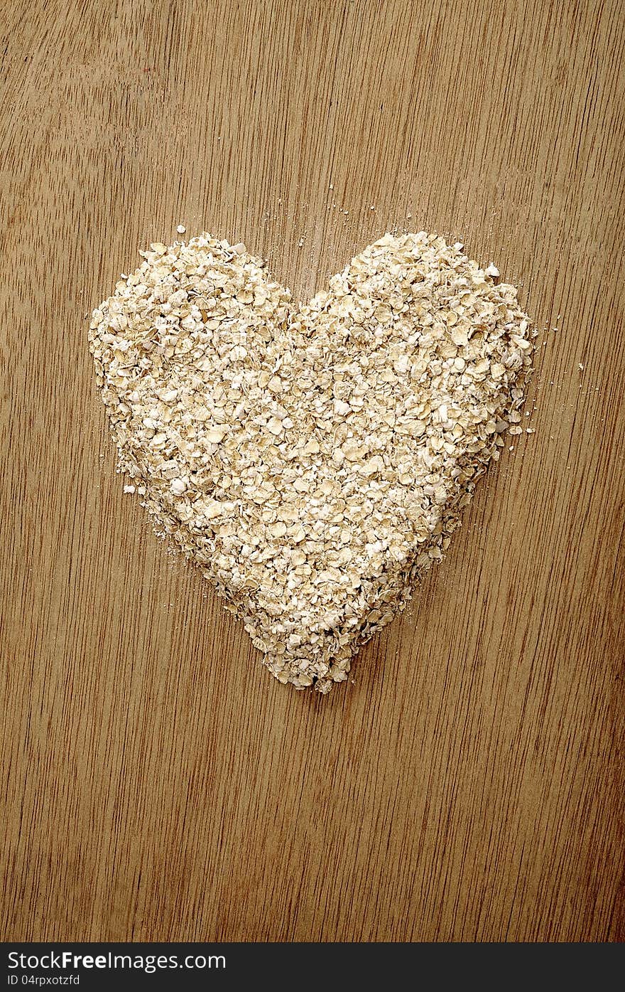 Heart shape oatmeal on wooden background. Good for healty food concept