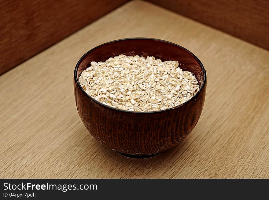 Oatmeal in the wooden bowl. This is healthy food concept. Oatmeal in the wooden bowl. This is healthy food concept