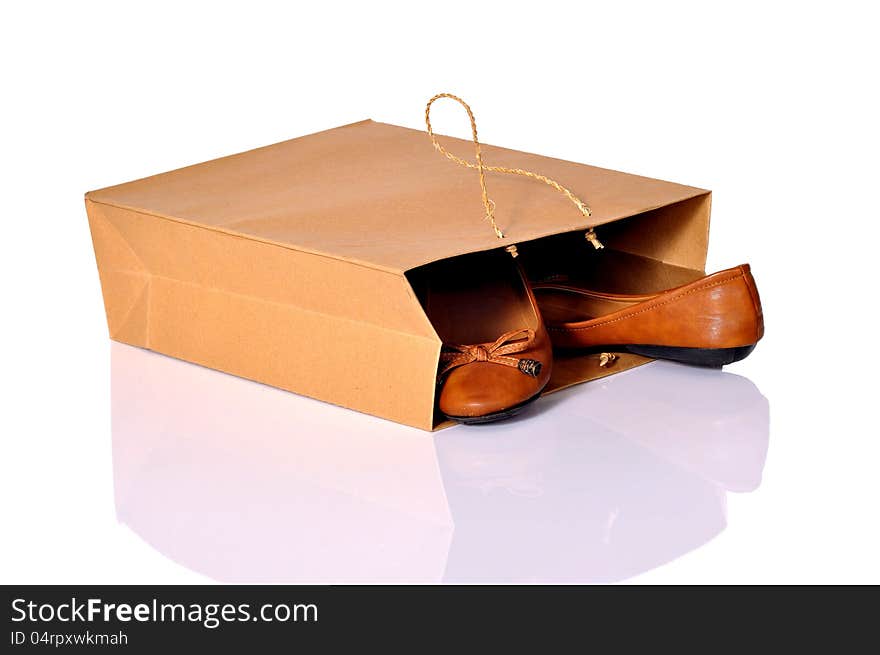 Brown shoes inside brown shopping bag over white background. Brown shoes inside brown shopping bag over white background