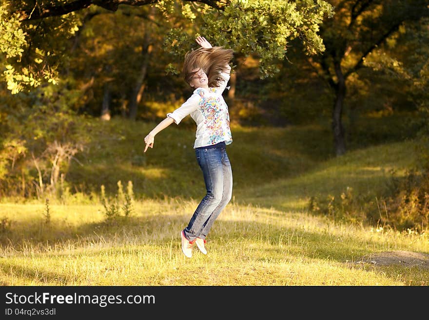 Young pretty woman jumping in the autumn park. Young pretty woman jumping in the autumn park