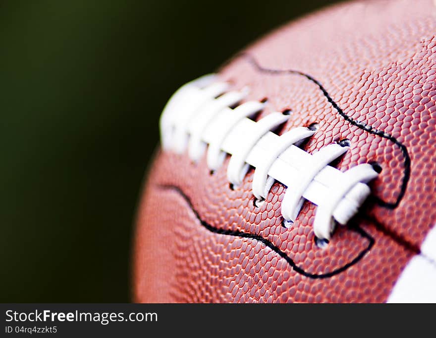 Close up of an american football against a black background