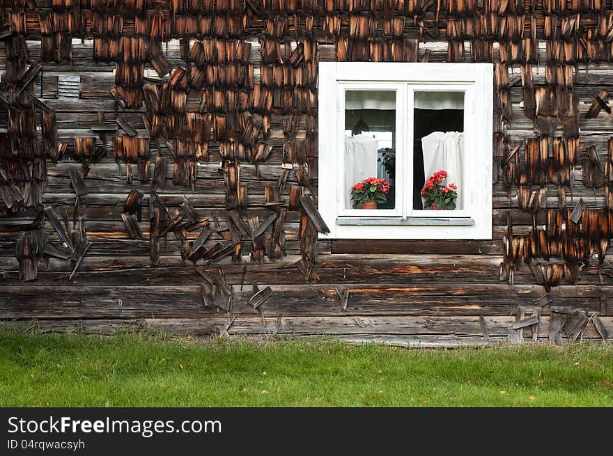 Old house wall with a windows and flowers.