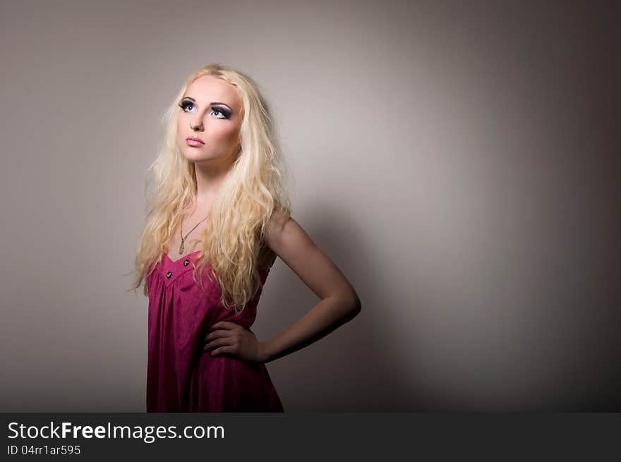 Blonde with a bright professional make-up on grey background. Blonde with a bright professional make-up on grey background