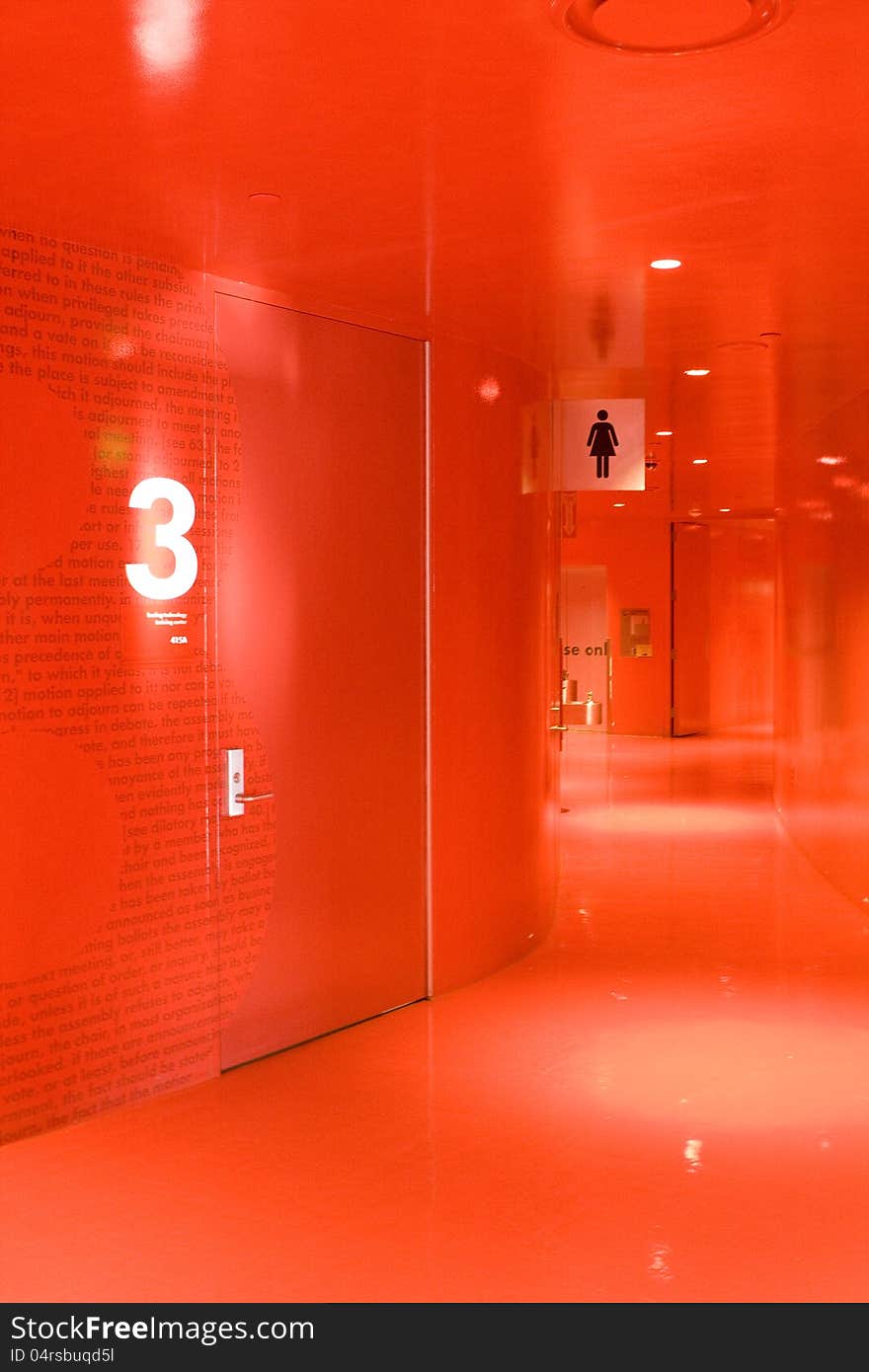 A totally red hallway with bathroom and exit sign