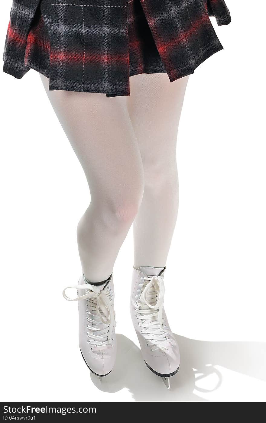 The legs of a figure skater wearing white tights, a checkered dress and ice skates on a white background. The legs of a figure skater wearing white tights, a checkered dress and ice skates on a white background