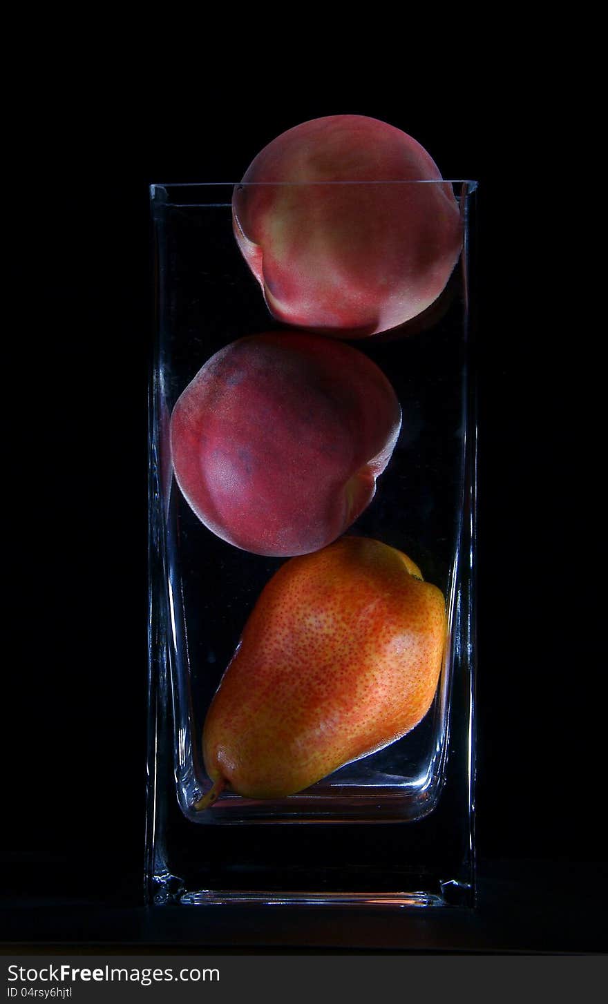 Pears and peaches in a vase on a black background. Pears and peaches in a vase on a black background.